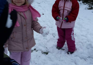 Na śniegu stoją dwie dziewczynki