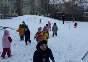 Dzieci stoją rozproszone na śniegu