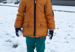 Chłopiec stoi na śniegu