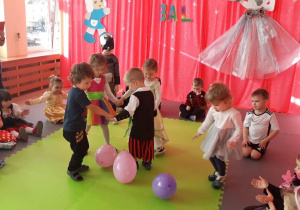 Czworo dzieci tańczy wokół baloników