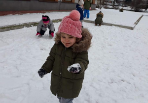 Dziewczynka trzyma kulę śniegową w dłoni