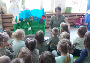 Nauczycielka siedzi na macie, zadaje pytania dzieciom