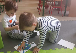Chłopiec układa puzzle przygotowane przez nauczycielkę