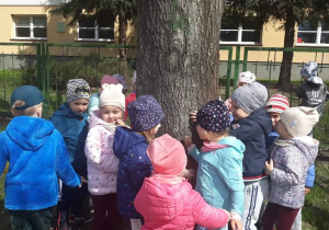 Dzieci stoją wokół drzewa