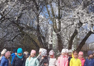 Dzieci stoją na tle drzewa