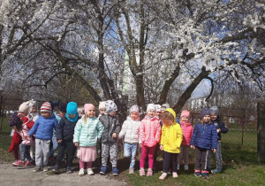 Dzieci pozują do zdjęcia na tle drzewa