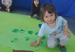 Chłopiec trzyma dłoń na papierowym drzewie