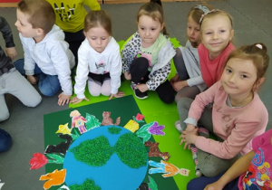 Dzieci prezentują pracę plastyczną o tematyce "Planeta Ziemia".