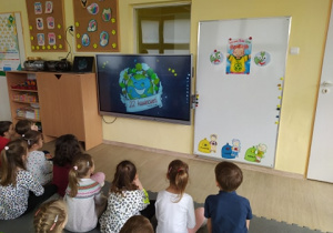 Dzieci oglądają prezentacje multimedialną na temat Naszej Planety Ziemi.