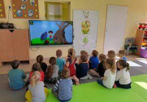 Dzieci oglądają film "Przygoda drzewa".