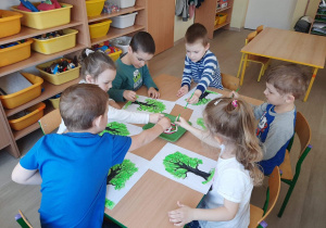 Dzieci stemplują obrazek - konar drzewa.