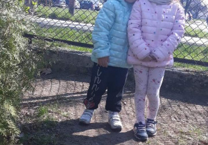dwie dziewczynki stoją na placu zabaw