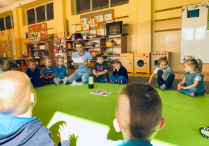 Nauczycielka odczytuje dzieciom list od unijnej maskotki - Syriusza.