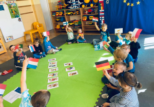 Dzieci prezentują flagi państw członkowskich UE, które wylosowały.