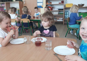 Dzieci jedzą placuszki przy stoliku