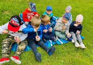 Maluchy zjadają lody w kubeczkach.