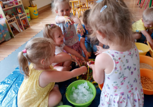 Dzieci śmieją się przy zabawie z makaronem.