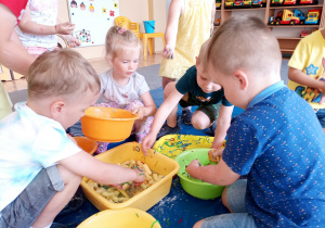 Dzieci wspólnie przygotowują "zupę" z różnych produktów.