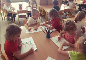 Dzieci uzupełniają rytm kolorowych kropek na kartce