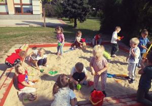 Dzieci budują w piaskownicy królestwo dla Kropki