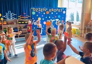 Dzieci tańczą z kolorowymi połówkami kół.