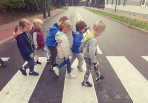 Dzieci przechodzą przez jezdnię w wyznaczonym miejscu dla pieszych