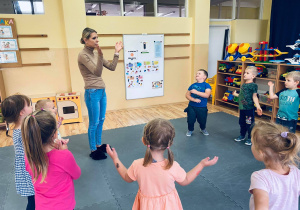 Przedszkolaki z nauczycielką tańczą do piosenki.