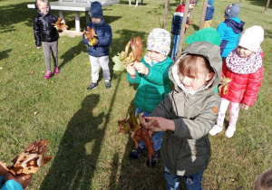 Dzieci pokazują znalezione barwne liście.