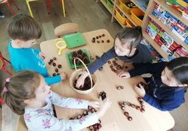 dzieci układają kasztanowe litery