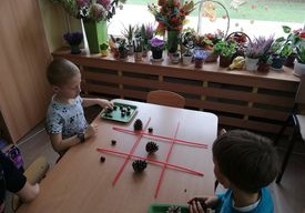 chłopcy grają w kółko i krzyżyk darami natury