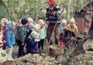 Dzieci oglądają pień drzewa w którym mieszkają skrzaty