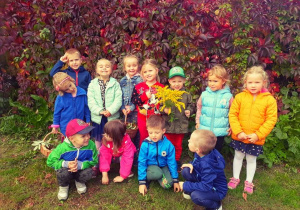 Dzieci pozują do wspólnej fotografii,w tle widać jesienną scenerię