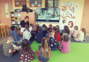 Dzieci słuchają nauczycielki, która wyjaśnia im co to są elektrośmieci