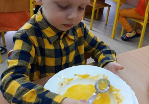 Chłopiec zjada zupę dyniową