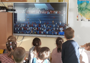 Dzieci oglądają film o tradycjach związanych z dniem wWszystkich Świętych