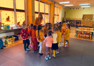 Dzieci wraz z nauczycielką inscenizują wierszyk o dyni.