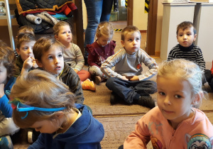 Dzieci siedzą na dywaniku