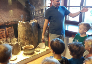 Przewodnik omawia z dziećmi eksponaty znajdujące się w muzeum