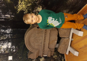 Chłopiec pozuje przy monumencie