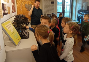 Dzieci oglądają maszyny do pisania z dawnych lat