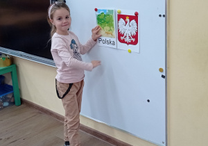 Dziewczynka wiesza mapę Polski na tablicy