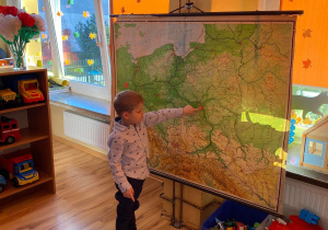 Wiktor wskazuje na mapie stolicę Polski.