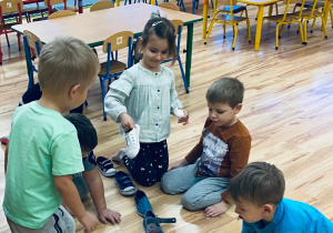 Dzieci przekładają buciki, jeden za drugim.