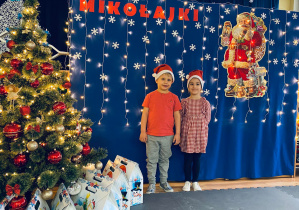 Paula i Sebastianek pozują do zdjęcia na tle świątecznej dekoracji.