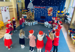 Dzieci w oczekiwaniu na Mikołaja powtarzają przygotowaną piosenkę i wierszyk.