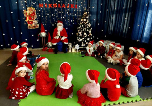 Dzieci słuchają co ma im do powiedzenia Święty Mikołaj