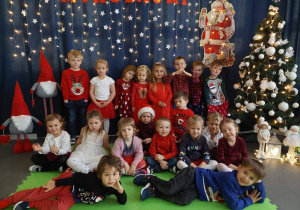Dzieci pozują do wspólnej fotografii w tle świąteczna sceneria