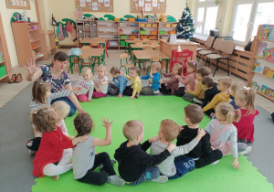 Dzieci siedzą w kole jedno za drugim