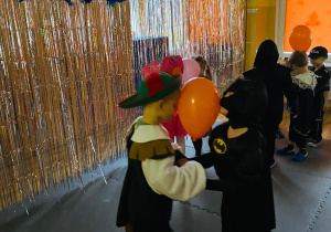 Antoś z Wiktorem tańczą trzymając balon pomiędzy głowami.