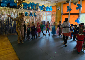 Przedszkolaki tworzą pociąg i tańczą do piosenki "Jedzie pociąg z daleka".